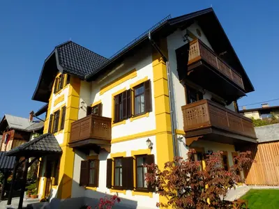 a yellow and white building with balconies on it at Vila Mila in Bled