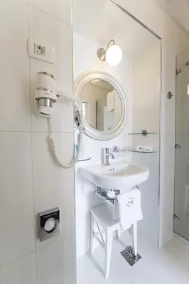 a white bathroom with a sink and a mirror at Vila Mila in Bled
