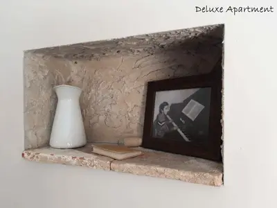 a framed picture on a stone shelf with a vase at Apartment Villa Carolina in Kranjska Gora