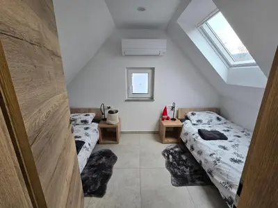 two twin beds in a room with two windows at Apartma Termal Čatež - nastanitev z vključenimi 6-imi kopalnimi kartami - 6 tickets included in Čatež ob Savi