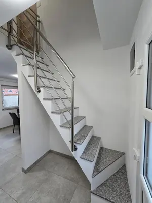 a staircase in a home with white walls and concrete floors at Apartma Termal Čatež - nastanitev z vključenimi 6-imi kopalnimi kartami - 6 tickets included in Čatež ob Savi