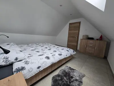 a bedroom with a bed and a wooden cabinet at Apartma Termal Čatež - nastanitev z vključenimi 6-imi kopalnimi kartami - 6 tickets included in Čatež ob Savi