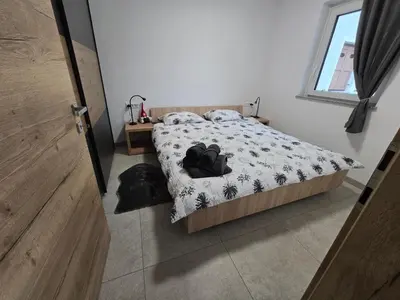 a bedroom with a bed with a black and white comforter at Apartma Termal Čatež - nastanitev z vključenimi 6-imi kopalnimi kartami - 6 tickets included in Čatež ob Savi