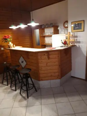 a kitchen with a bar with stools in front of it at Ranc Polo Velka sobe in Zgornja Velka