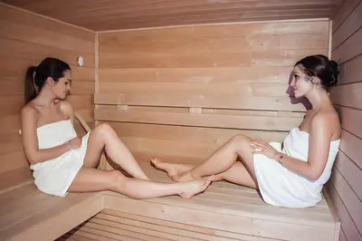 two young women sitting in a sauna at Ranc Polo Velka sobe in Zgornja Velka