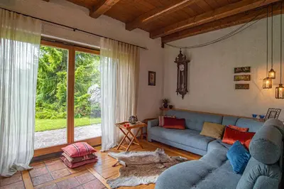 a living room with a blue couch and a large window at Chalet Zala in Kranjska Gora