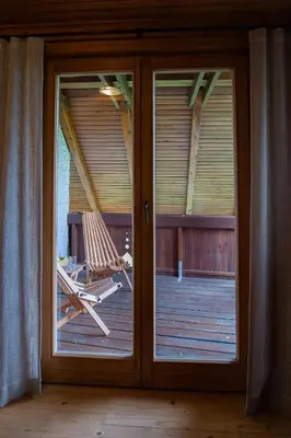 a sliding glass door with a hammock on a deck at Chalet Zala in Kranjska Gora