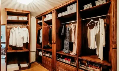 a large wooden closet with open shelves and clothes at Opulent Villa with Sauna in the Heart of Karst in Dutovlje