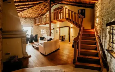 a living room with a staircase and a couch at Opulent Villa with Sauna in the Heart of Karst in Dutovlje