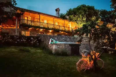 a house with a bike parked in front of it at Opulent Villa with Sauna in the Heart of Karst in Dutovlje