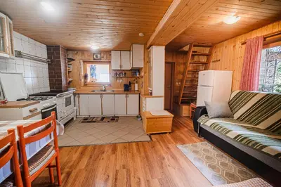 a kitchen and living room with a couch in a room at Cottage of Rising Sun in Goreljek