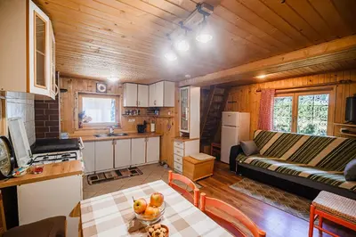 a kitchen and a living room with a couch and a table at Cottage of Rising Sun in Goreljek