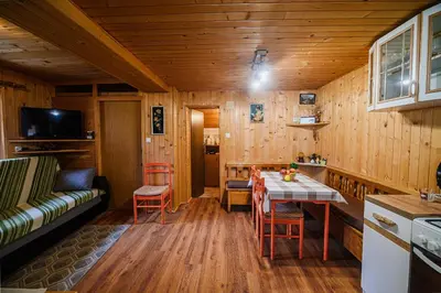 a kitchen and living room with a table and chairs at Cottage of Rising Sun in Goreljek