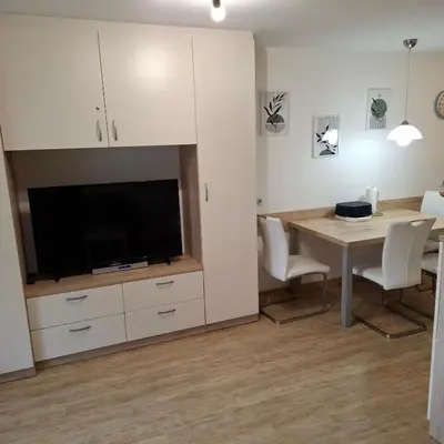 a kitchen and dining room with a table and a tv at Bohinj Planika J2 in Bohinj
