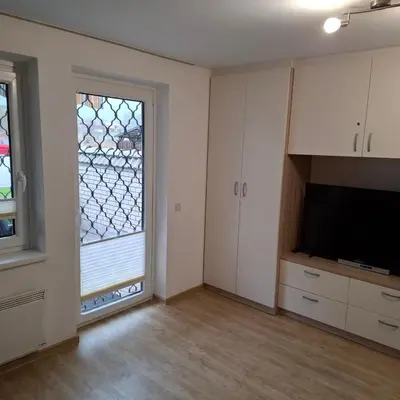 an empty living room with a tv and a window at Bohinj Planika J2 in Bohinj