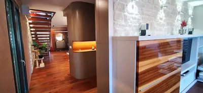 a living room with a fireplace and wooden floors at Sončna oaza - Vila Melita in Moravske Toplice