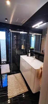 a bathroom with a white sink and a shower at Sončna oaza - Vila Melita in Moravske Toplice