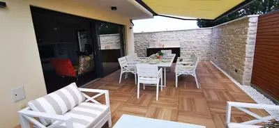 a dining room with a table and chairs on a patio at Sončna oaza - Vila Melita in Moravske Toplice