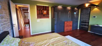 a bedroom with a bed and a stone wall at Sončna oaza - Vila Melita in Moravske Toplice