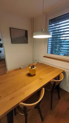 a wooden table with two chairs and a bowl on top at Modern apartment Konjice in Slovenske Konjice