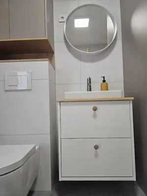 a white bathroom with a sink and a mirror at Modern apartment Konjice in Slovenske Konjice