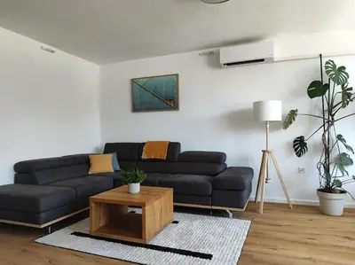 a living room with a black couch and a table at Modern apartment Konjice in Slovenske Konjice