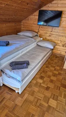 two beds in a room with a tv on the wall at Suita 305 in Kranjska Gora