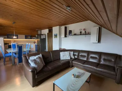a living room with a brown leather couch and a table at Spacious Countryside Flat - 25 minutes from Ljubljana in Grosuplje