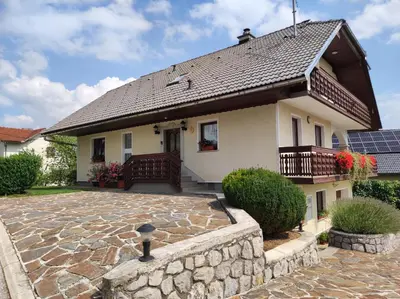 a house with a stone patio in front of it at Spacious Countryside Flat - 25 minutes from Ljubljana in Grosuplje