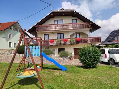 a yard with a playground in front of a house at Spacious Countryside Flat - 25 minutes from Ljubljana in Grosuplje