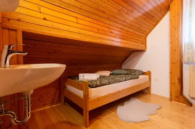a bathroom with a bed and a sink in a room at Pohorski Dom in Pohorje