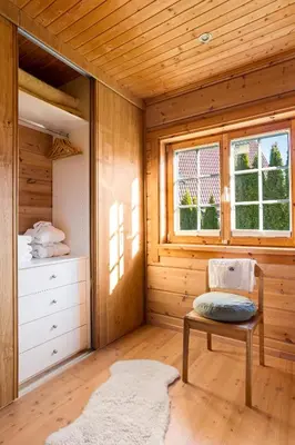 a room with a bed and a bench in a wooden room at Wellness Chalet close to Ljubljana in Rakitna