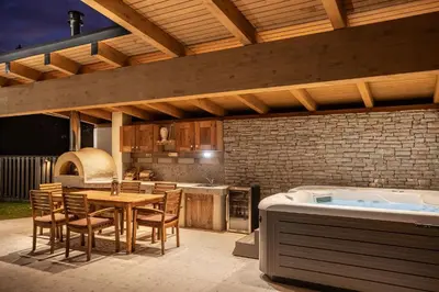 a kitchen with a table and a bath tub at Wellness Chalet close to Ljubljana in Rakitna