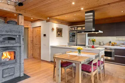 a kitchen with a table and a fireplace at Wellness Chalet close to Ljubljana in Rakitna
