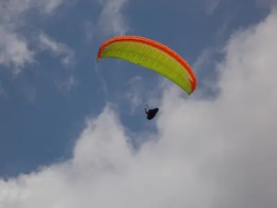a person riding a parachute in the sky at Apartment and Room Natasa in Kobarid