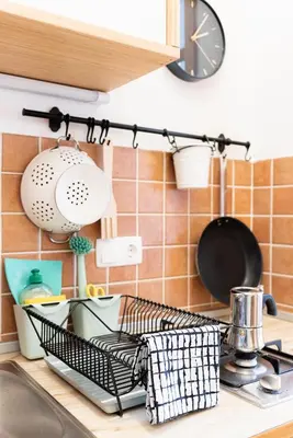 a kitchen sink with a dish drying rack and a clock at Bridget's room in Ljubljana