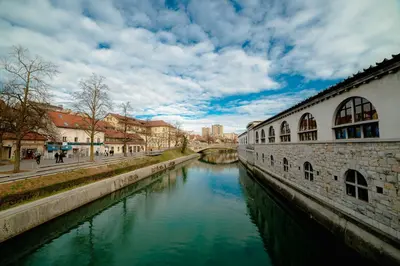 a river in a city with buildings and a bridge at Bridget's room in Ljubljana