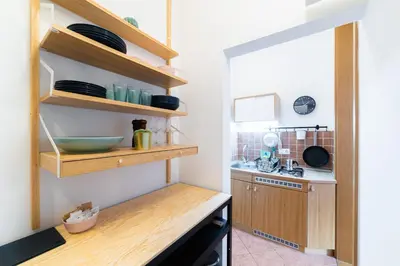 a kitchen with wooden shelves and a sink at Bridget's room in Ljubljana