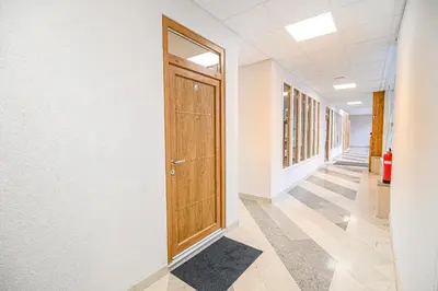 a hallway of an office building with a wooden door at Apartment Gorski Raj in Kranjska Gora