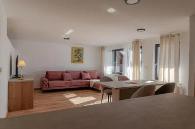 a living room with a red couch and a table at Hiša S'TJE Krvavec ski resort in Cerklje na Gorenjskem