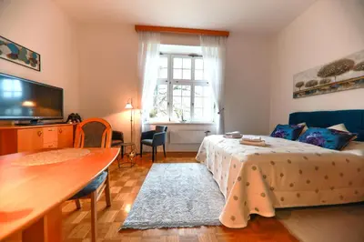 a bedroom with a bed and a table and a television at Apartments at Villa Golf in Rogaška Slatina