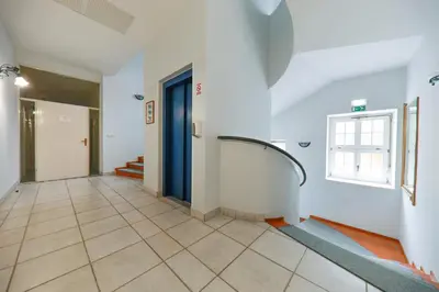 a hallway with a blue door and a tile floor at Apartments at Villa Golf in Rogaška Slatina