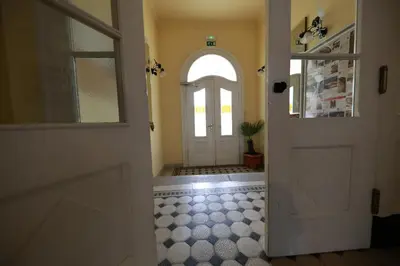 a hallway with a white door and a tile floor at Apartments at Villa Golf in Rogaška Slatina