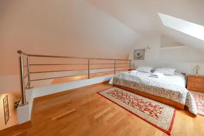 a bedroom with a bed and a staircase at Apartments at Villa Golf in Rogaška Slatina