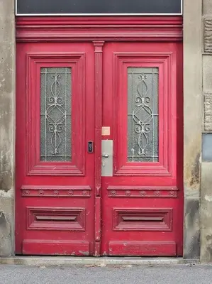 a red door with two windows on a building at Old city life in Maribor