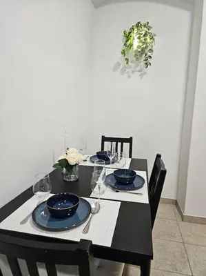 a black table with black chairs and blue dishes on it at Old city life in Maribor