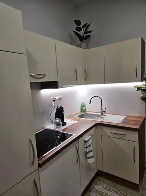a small kitchen with white cabinets and a sink at Old city life in Maribor