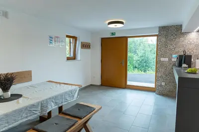 a room with a table and a kitchen with a door at Zidanica sredi dolenjskih gričev - V gaj in Trebnje