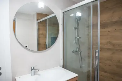 a bathroom with a shower with a sink and a mirror at Zidanica sredi dolenjskih gričev - V gaj in Trebnje