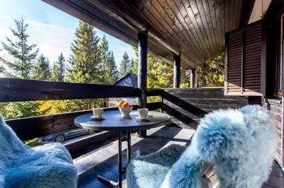a patio with two chairs and a table on a deck at Apartma Planinski Raj in Zreče